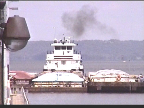 Tug pushing a set of barges toward the lock